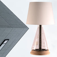 Modern industrial table lamp with rustic bronze and copper hardware, glass, wood base, and beige lamp shade